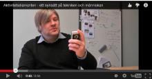 P. O. Hedvall berättar med en mobiltelefon i handen